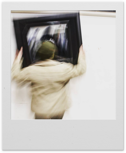 A recording setup. Headphones sit on a microphone stand that holds a Neumann TLM103 microphone. A small audio interface sits on a raised desk. Adobe Audition is on a monitor showing a recently recorded waveform.